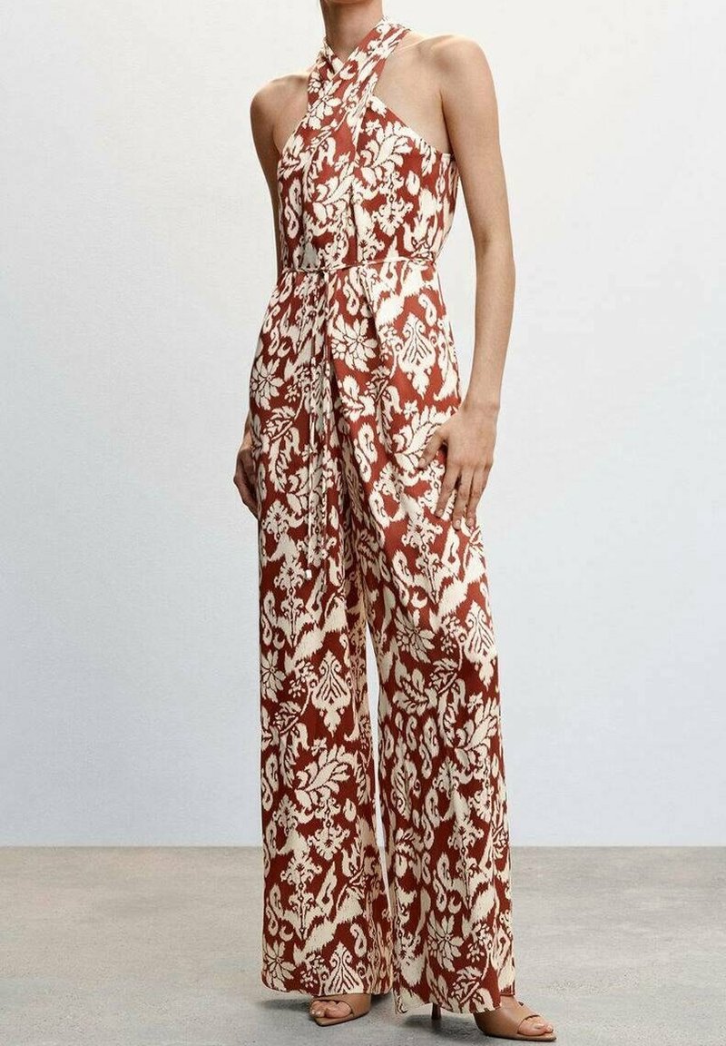 Combinaison sans manches à jambes larges avec motif floral rouille et crème, avec un col halter croisé et une ceinture nouée à la taille.