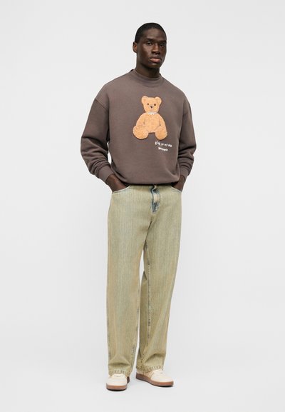 Σκούρα γκρι φούτερ με απαλό σχέδιο αρκουδάκι, σε συνδυασμό με ανοιχτό πράσινο ριγέ παντελόνι. Διαθέτει στρογγυλή λαιμόκοψη και άνετη εφαρμογή.