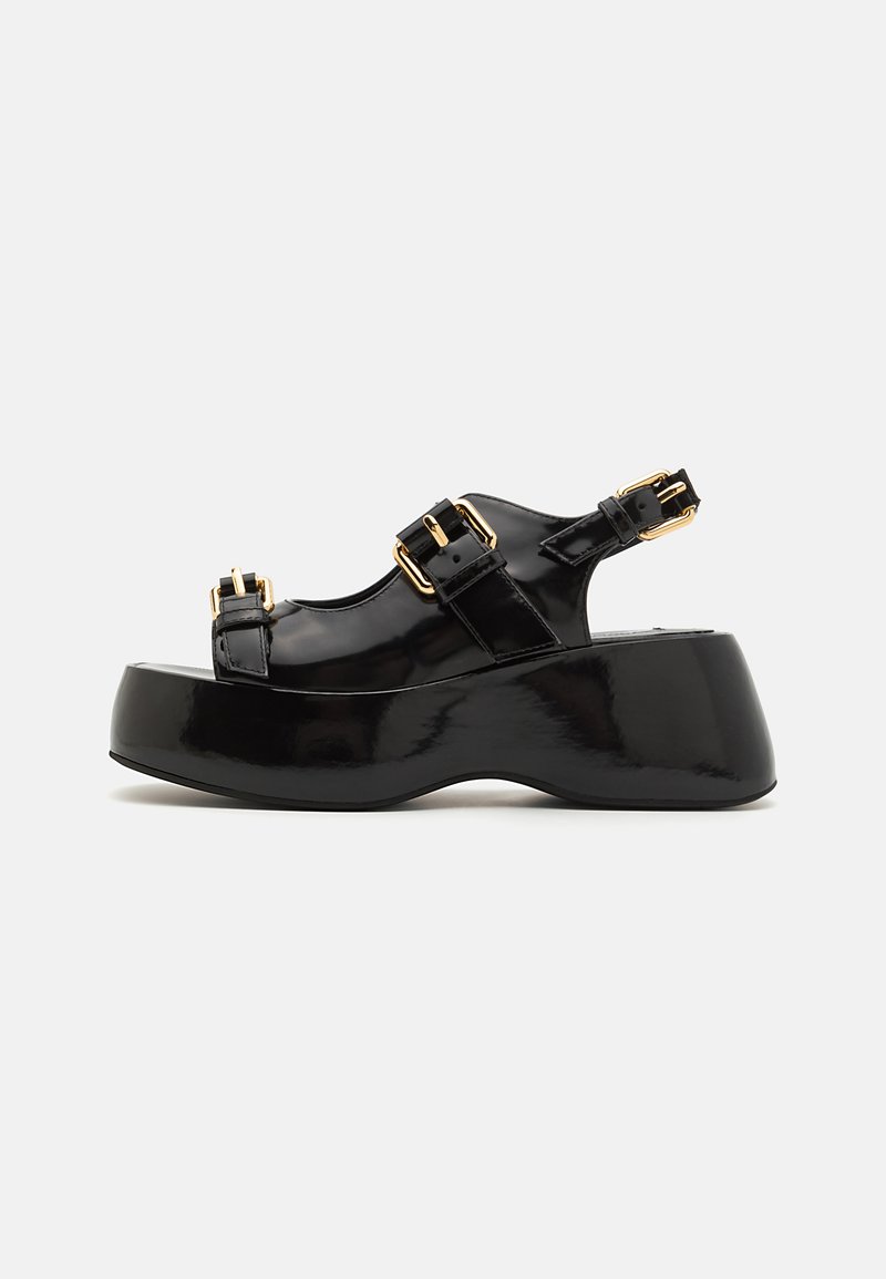Black patent leather platform sandals feature a chunky heel, two adjustable buckle straps, and a smooth, glossy finish.