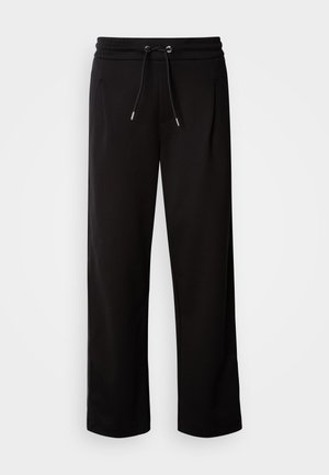 Zwarte, loszittende joggingbroek van zachte stof, met een elastische tailleband met een trekkoord en zijzakken.