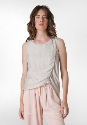 Top sin mangas de color gris claro con un escote redondo y detalle de fruncido en los lados, combinado con pantalones de tiro ajustado de color rosa claro con cordón. Textura de tela suave.