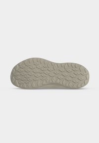 Semelle de chaussure beige clair avec motif en losange et chevrons, conçue pour l’adhérence, présentée sur fond blanc uni.