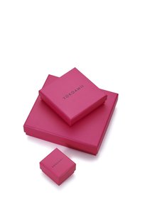 Trys rožinės spalvos dovanų dėžutės skirtingų dydžių, matinio paviršiaus, kvadratinės formos, ant vidurinės dėžutės viršaus juodu užrašytas žodis „YOKOAMii“.