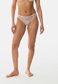 Vatsapanta vaaleanpunaisena, jossa on monimutkaisia kuvioita, pehmeä rakenne ja matala vyötärö, korostaen hentoa vyötäröä ja leikkausta.