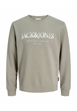 Roheline pusa ümarate kaelustega, pikkade varrukatega, millel on rinnal silmapaistev valge logo ja teksid.