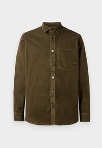 Camisa abotonada de algodón en verde oliva oscuro, con cuello puntiagudo, un bolsillo en el pecho y dobladillo redondeado con sutiles detalles de costura.