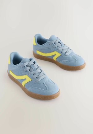 Mėlyni anteleginiai sportbačiai su geltonais akcentais, struktūrizuoti guminiai padai ir klasikinis raištelių užsegimas. Lengvi ir turi paminkštintą apykaklę patogumui.