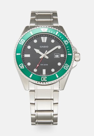 Casio watch with stainless steel band, black dial, green bezel, white hour markers, date display at 3 o'clock, water-resistant 200m.