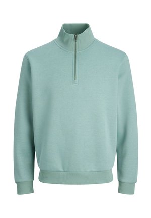 Šviesiai žalias ketvirtinis džemperis su ribotais rankogaliais ir liemeniu. Pagamintas iš minkštos medžiagos, turi aukštą apykaklę ir minimalistin į dizainą.