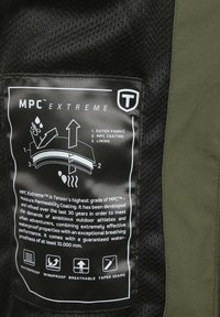 Zwarte en olijfgroene stoffen etikette met witte tekst; details bevatten onderhoudsinstructies en kenmerken van de MPC Extreme coating voor waterdichtheid.