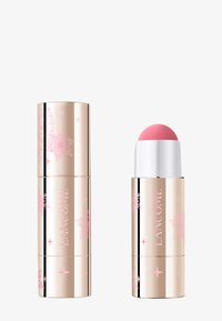 Crayon blush crème Lancome avec un capuchon cylindrique doré, orné de motifs floraux roses et une pointe applicatrice arrondie rose.