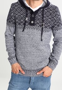 Pullover-Hoodie in Marineblau und Grau mit Rautenmuster, verfügt über eine Kapuze mit Kordelzug und zwei Knöpfe am Ausschnitt. Strukturierter Stoff.