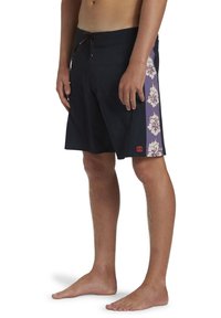 Bañadores negros con cintura ajustable, que presentan paneles laterales morados adornados con un patrón floral blanco. Textura suave y diseño ligero.