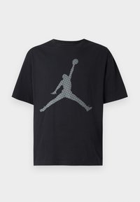 Sort bomulds t-shirt med korte ærmer, der har en stor grå silhuet af en basketballspiller i en ikonisk pose trykt på forsiden.