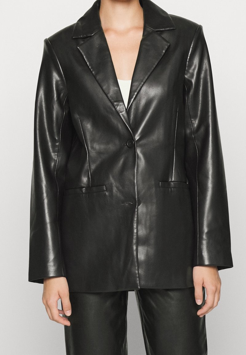 Černé kožené sako s klopovým límcem s výřezem, zapínáním na jeden knoflík a dvěma předními kapsami s hladkou, lesklou texturou.