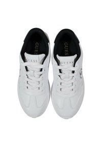 Baskets blanches avec une finition en cuir lisse, dotées d'une doublure intérieure noire, de lacets ronds et du logo "GUESS" sur les côtés.
