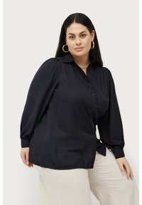 Donkerblauwe blouse met knoopsluiting en lange pofmouwen, en een kraag. Gemaakt van een soepel stof, met een relaxte pasvorm en zijsplitten.