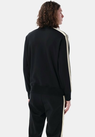 Black sweatshirt with beige side stripes, featuring a textured fabric, crew neck, and ribbed cuffs. Back view shows a relaxed fit and smooth silhouette.