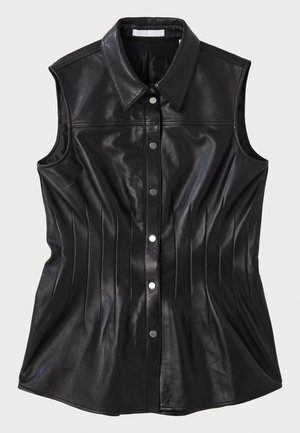 Melnas ādas bez piedurknēm krekls ar punktveida apkakli, vertikālām šuvēm un plastmasas pogām, kas aizpogājas priekšpusē.