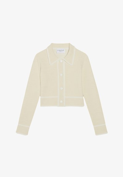 Cárdigan corto de color crema con cuello de solapa, cinco botones blancos y costuras contrastantes en blanco a lo largo de los bordes y las mangas. Textura suave.