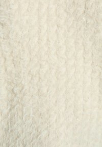 Tessuto a maglia color crema con una texture soffice, caratterizzato da un motivo a treccia in rilievo e sottili luccichii di paillettes sparse.