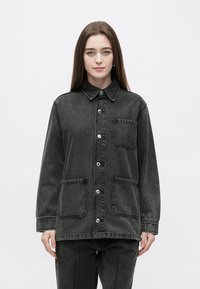 Temno siva jeans jakna z ovratnikom, gumbi spredaj in dvema obližnima žepoma. Ima sproščen kroj in mat teksturo.