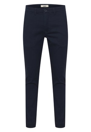 Tummansiniset housut, jotka on valmistettu puuvillasekoitteesta. Niissä on nappikiinnitys, sivutaskut ja joustavat hihnat nilkoissa.