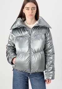 Casaco puffer prateado com um acabamento brilhante, colarinho oversized, fecho de zipper na frente e textura franzida ao longo do corpo e das mangas.