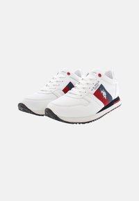 Scarpe sportive bianche con parte superiore in rete e sintetico, dettagli in rosso e blu navy, suola in gomma testurizzata e logo sul lato.