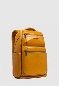 Gele, glanzende rugzak met een gestructureerd ontwerp. Voorzien van meerdere ritssluitingen, gevoerde bandjes en een bovenste handvat voor draaggemak.