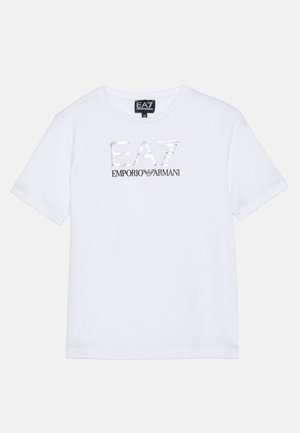 T-shirt blanc à manches courtes avec logo argenté "EA7" et noir "Emporio Armani" imprimé sur la poitrine, et une étiquette de logo noire à l’intérieur du col.