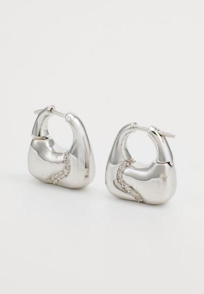 Metallic silver hoop earrings featuring a smooth, rounded design with a curved line of gemstones for added detail.