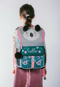 Kinderrucksack in Türkis, verziert mit einem Panda-Gesicht, floralen Mustern, pinken Akzenten, weichem Material und Pom-Pom-Dekorationen.