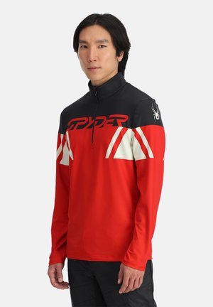 Rood en zwart lange mouw pullover met een halve ritssluiting, met witte accenten en een Spider-logo op de schouder. Glad materiaal, sportieve pasvorm.