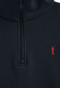 Pullover con zip di colore blu navy realizzato in tessuto textured, dotato di un collo alto e di un piccolo emblema rosso di golfista sul lato sinistro del petto.