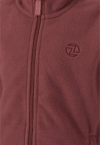 Bordeaux fleece zip-jacket med høj krave, tekstureret stof og et subtilt logo prægede på brystet. Har en lynlås i fuld længde.