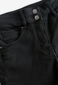 Czarne dżinsy z denimu o gładkiej teksturze, wyposażone w dwa metalowe guziki w pasie, boczną kieszeń oraz subtelne detale przeszyć.