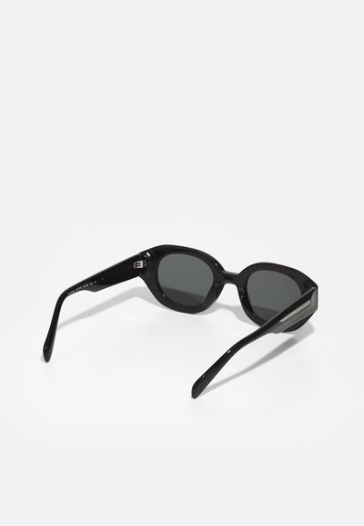 Ochelari de soare din plastic negru, cu formă rectangulară și lente de culoare gri închis. Au brațe groase cu un accent metalic subtil la balama.