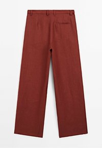 Pantalon à jambes larges en tissu rouge profond, avec une texture lisse, quatre passants de ceinture et une poche arrière. Conçu pour une coupe décontractée.