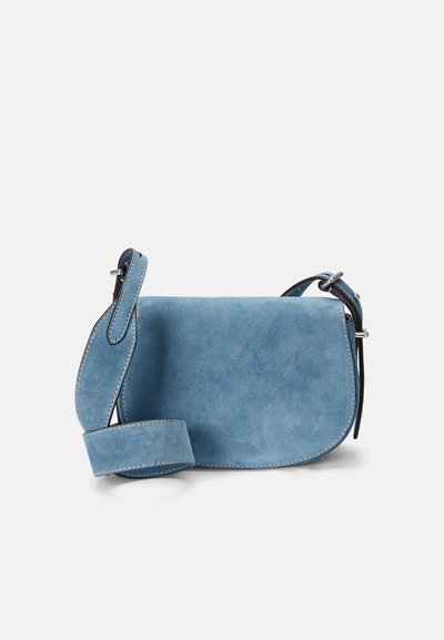 Modra usnjena torba za rame s ukrivljeno obliko, dekorativnim šivom, kontrastnim črnim trakom in gladko teksturo.