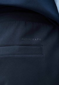 Felpa blu navy in tessuto morbido, con un piccolo logo tonale "AUTOGRAPH" e orlo a costine coordinato.