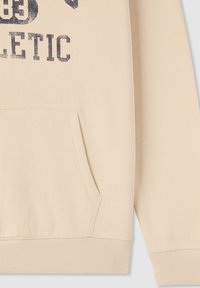 Felpa beige con tasca a marsupio, polsini a coste e stampa testurizzata "ATHLETIC" in blu scuro. Tessuto morbido con una finitura liscia.