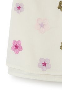 Weißer Stoff mit gestickten Blumen in Pink, Lila und Grün. Jede Blume hat eine ausgeprägte Texturstichweise, die die visuelle Detailtreue verstärkt.