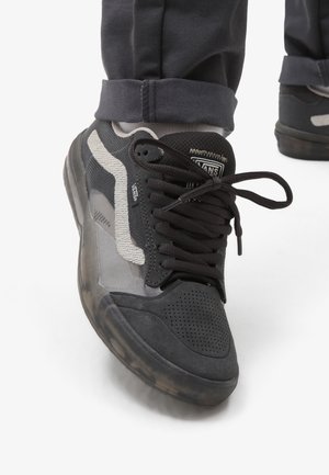 Černošedé tenisky z materiálů síťoviny a semiše, s polstrovaným jazykem a šněrováním. Mají výrazné logo a gumovou podrážku.