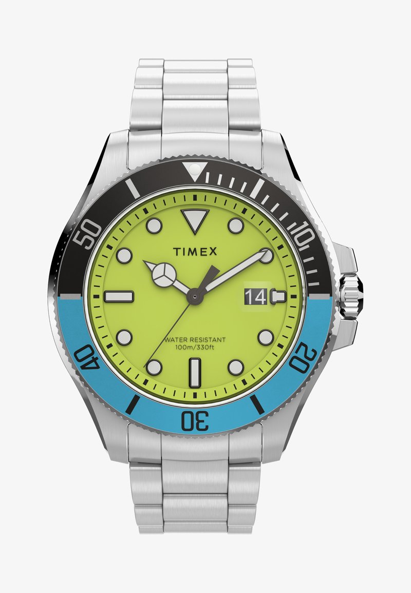 Zegarek Timex z jasną żółtą tarczą, czarnym i niebieskim pierścieniem, bransoletą ze stali nierdzewnej oraz świecącymi znacznikami godzin. Wodoodporny do 100 m.