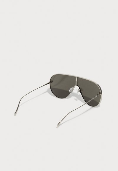 Silver metal aviator sunglasses with dark grey lenses, thin wire arms, and clear nose pads for comfort. Minimalist design with no patterns.