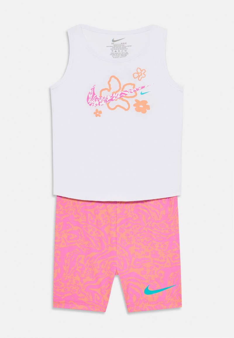 Biely top s ramienkami so ružovou a oranžovou kvetinovou grafikou, spárovaný s ružovými šortkami s abstraktnými vzormi a tyrkysovým logom Nike.