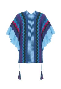 Blå stickad poncho med zigzag-mönster i lila, grönt och rött. Har volangärmar och fransar i nederkant. Mjuk textur.