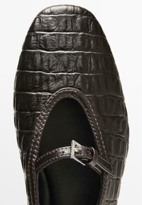 Braune, krokodil-geprägte Leder-Mary-Jane-Schuhe mit runder Zehenform und einem dünnen, verstellbaren Riemen mit Metall-Schnalle. Glatte, strukturierte Oberfläche.