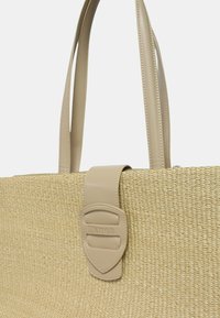Borsa a tracolla beige intrecciata con manici in pelle liscia e una tracolla coordinata con un accento del logo. Corpo testurizzato simile alla paglia.